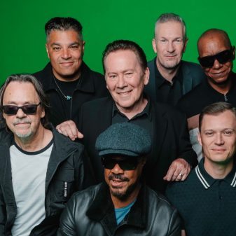 UB40 con Ali Campbell en vivo sobre el escenario, interpretando clásicos del reggae ante un teatro lleno