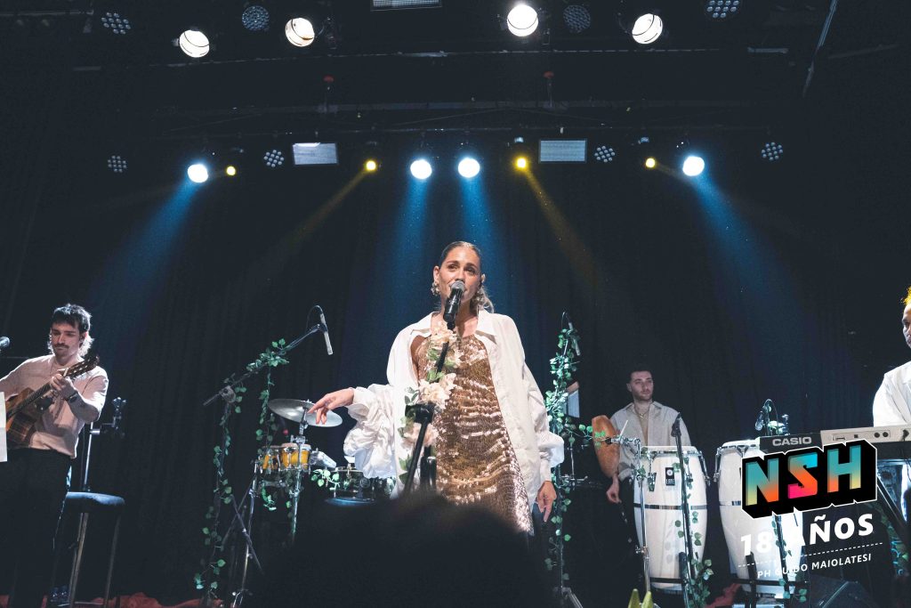 Rocío Igarzábal interpretando canciones de Volare en vivo en La Tangente
Escena del show de Rocío Igarzábal con vestuario etéreo durante Volare
El público emocionado en el recital de Rocío Igarzábal en Buenos Aires
Dueto entre Rocío Igarzábal y El Purre en La Tangente
Cambio de vestuario de Rocío Igarzábal en su presentación de Volare
Potra y Rocío Igarzábal en una interpretación íntima durante el show
Vista del escenario iluminado durante el concierto de Volare en La Tangente
Rocío Igarzábal celebrando con el público al final de su show en vivo
Momentos festivos del recital de Rocío Igarzábal con coreografía y luces
Detalle del EP Volare presentado por Rocío Igarzábal en La Tangente
