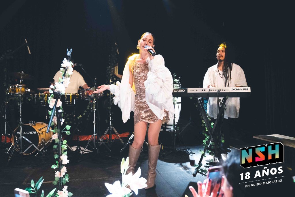 Rocío Igarzábal interpretando canciones de Volare en vivo en La Tangente
Escena del show de Rocío Igarzábal con vestuario etéreo durante Volare
El público emocionado en el recital de Rocío Igarzábal en Buenos Aires
Dueto entre Rocío Igarzábal y El Purre en La Tangente
Cambio de vestuario de Rocío Igarzábal en su presentación de Volare
Potra y Rocío Igarzábal en una interpretación íntima durante el show
Vista del escenario iluminado durante el concierto de Volare en La Tangente
Rocío Igarzábal celebrando con el público al final de su show en vivo
Momentos festivos del recital de Rocío Igarzábal con coreografía y luces
Detalle del EP Volare presentado por Rocío Igarzábal en La Tangente