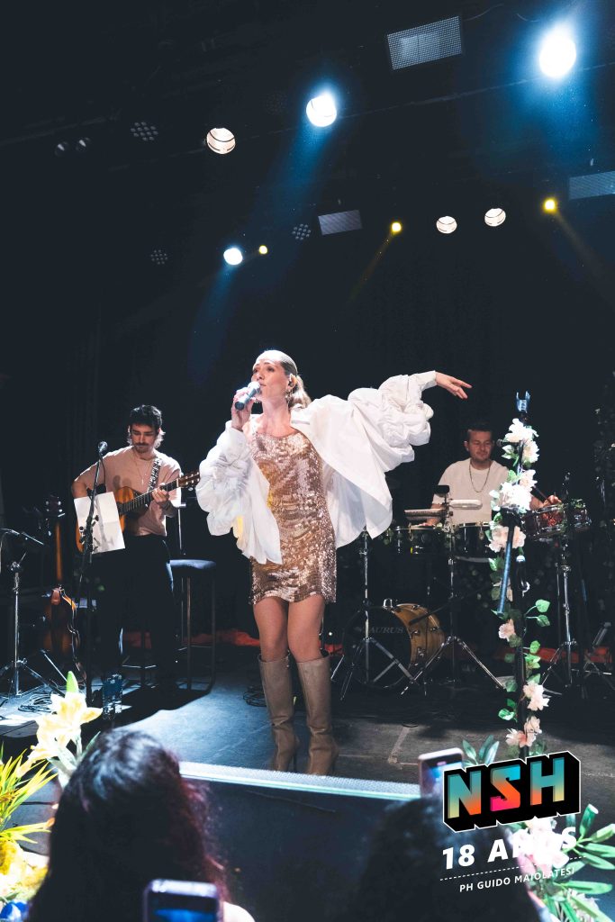 Rocío Igarzábal interpretando canciones de Volare en vivo en La Tangente
Escena del show de Rocío Igarzábal con vestuario etéreo durante Volare
El público emocionado en el recital de Rocío Igarzábal en Buenos Aires
Dueto entre Rocío Igarzábal y El Purre en La Tangente
Cambio de vestuario de Rocío Igarzábal en su presentación de Volare
Potra y Rocío Igarzábal en una interpretación íntima durante el show
Vista del escenario iluminado durante el concierto de Volare en La Tangente
Rocío Igarzábal celebrando con el público al final de su show en vivo
Momentos festivos del recital de Rocío Igarzábal con coreografía y luces
Detalle del EP Volare presentado por Rocío Igarzábal en La Tangente