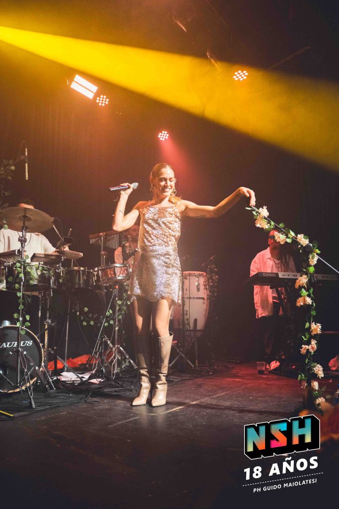 Rocío Igarzábal interpretando canciones de Volare en vivo en La Tangente
Escena del show de Rocío Igarzábal con vestuario etéreo durante Volare
El público emocionado en el recital de Rocío Igarzábal en Buenos Aires
Dueto entre Rocío Igarzábal y El Purre en La Tangente
Cambio de vestuario de Rocío Igarzábal en su presentación de Volare
Potra y Rocío Igarzábal en una interpretación íntima durante el show
Vista del escenario iluminado durante el concierto de Volare en La Tangente
Rocío Igarzábal celebrando con el público al final de su show en vivo
Momentos festivos del recital de Rocío Igarzábal con coreografía y luces
Detalle del EP Volare presentado por Rocío Igarzábal en La Tangente