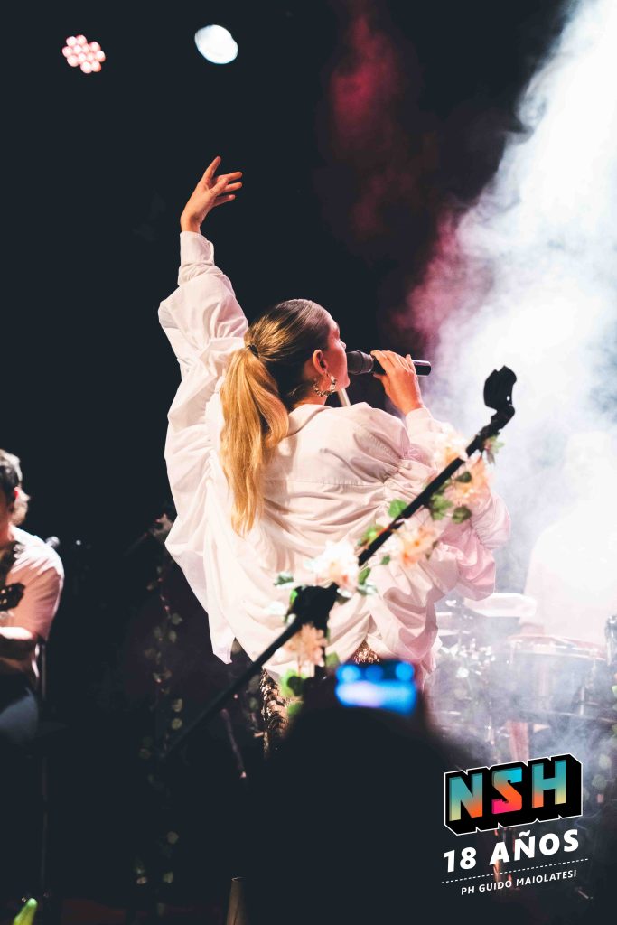 Rocío Igarzábal interpretando canciones de Volare en vivo en La Tangente
Escena del show de Rocío Igarzábal con vestuario etéreo durante Volare
El público emocionado en el recital de Rocío Igarzábal en Buenos Aires
Dueto entre Rocío Igarzábal y El Purre en La Tangente
Cambio de vestuario de Rocío Igarzábal en su presentación de Volare
Potra y Rocío Igarzábal en una interpretación íntima durante el show
Vista del escenario iluminado durante el concierto de Volare en La Tangente
Rocío Igarzábal celebrando con el público al final de su show en vivo
Momentos festivos del recital de Rocío Igarzábal con coreografía y luces
Detalle del EP Volare presentado por Rocío Igarzábal en La Tangente