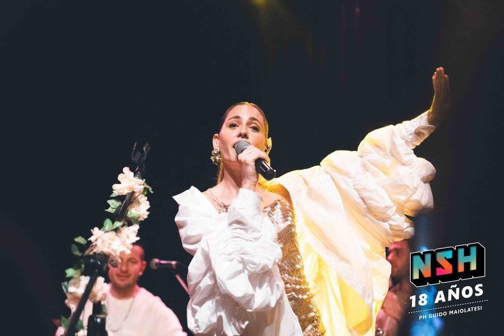 Rocío Igarzábal interpretando canciones de Volare en vivo en La Tangente
Escena del show de Rocío Igarzábal con vestuario etéreo durante Volare
El público emocionado en el recital de Rocío Igarzábal en Buenos Aires
Dueto entre Rocío Igarzábal y El Purre en La Tangente
Cambio de vestuario de Rocío Igarzábal en su presentación de Volare
Potra y Rocío Igarzábal en una interpretación íntima durante el show
Vista del escenario iluminado durante el concierto de Volare en La Tangente
Rocío Igarzábal celebrando con el público al final de su show en vivo
Momentos festivos del recital de Rocío Igarzábal con coreografía y luces
Detalle del EP Volare presentado por Rocío Igarzábal en La Tangente