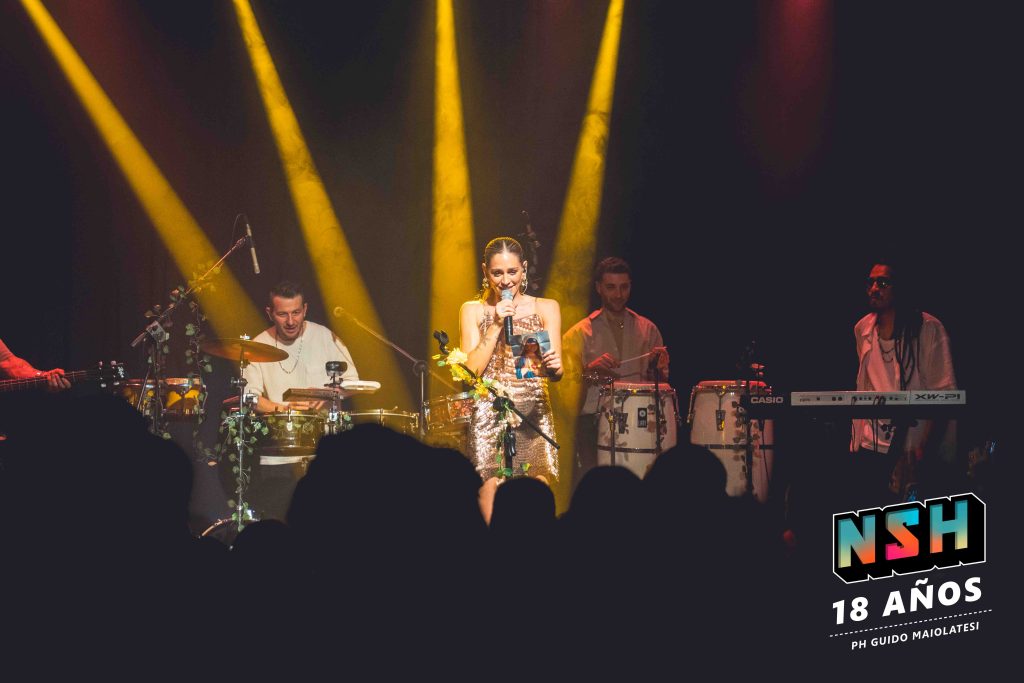Rocío Igarzábal interpretando canciones de Volare en vivo en La Tangente
Escena del show de Rocío Igarzábal con vestuario etéreo durante Volare
El público emocionado en el recital de Rocío Igarzábal en Buenos Aires
Dueto entre Rocío Igarzábal y El Purre en La Tangente
Cambio de vestuario de Rocío Igarzábal en su presentación de Volare
Potra y Rocío Igarzábal en una interpretación íntima durante el show
Vista del escenario iluminado durante el concierto de Volare en La Tangente
Rocío Igarzábal celebrando con el público al final de su show en vivo
Momentos festivos del recital de Rocío Igarzábal con coreografía y luces
Detalle del EP Volare presentado por Rocío Igarzábal en La Tangente
