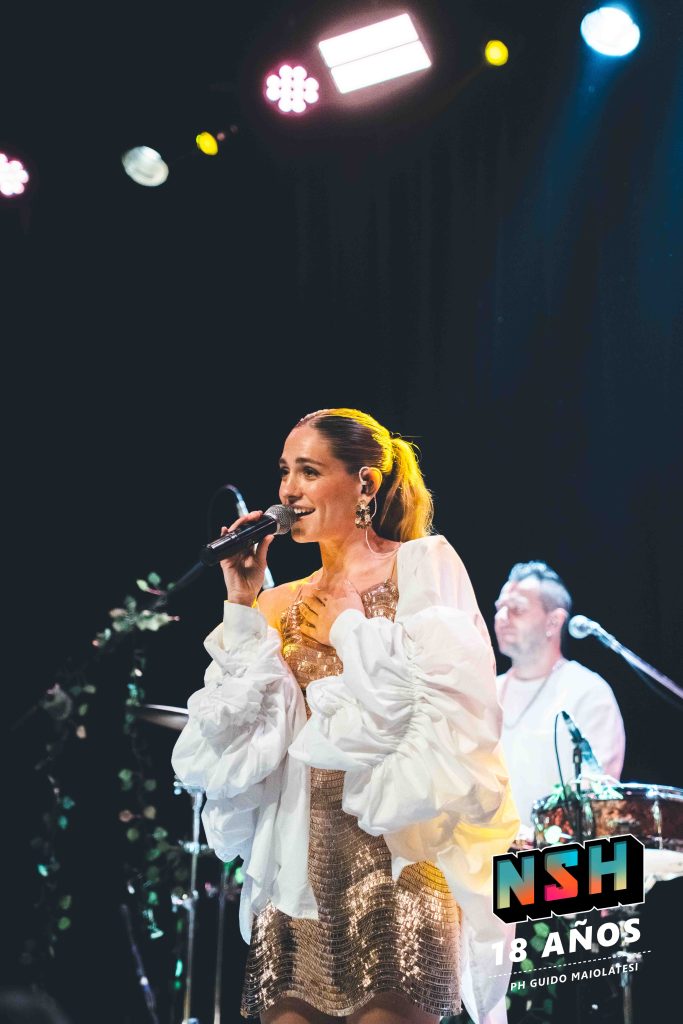 Rocío Igarzábal interpretando canciones de Volare en vivo en La Tangente
Escena del show de Rocío Igarzábal con vestuario etéreo durante Volare
El público emocionado en el recital de Rocío Igarzábal en Buenos Aires
Dueto entre Rocío Igarzábal y El Purre en La Tangente
Cambio de vestuario de Rocío Igarzábal en su presentación de Volare
Potra y Rocío Igarzábal en una interpretación íntima durante el show
Vista del escenario iluminado durante el concierto de Volare en La Tangente
Rocío Igarzábal celebrando con el público al final de su show en vivo
Momentos festivos del recital de Rocío Igarzábal con coreografía y luces
Detalle del EP Volare presentado por Rocío Igarzábal en La Tangente