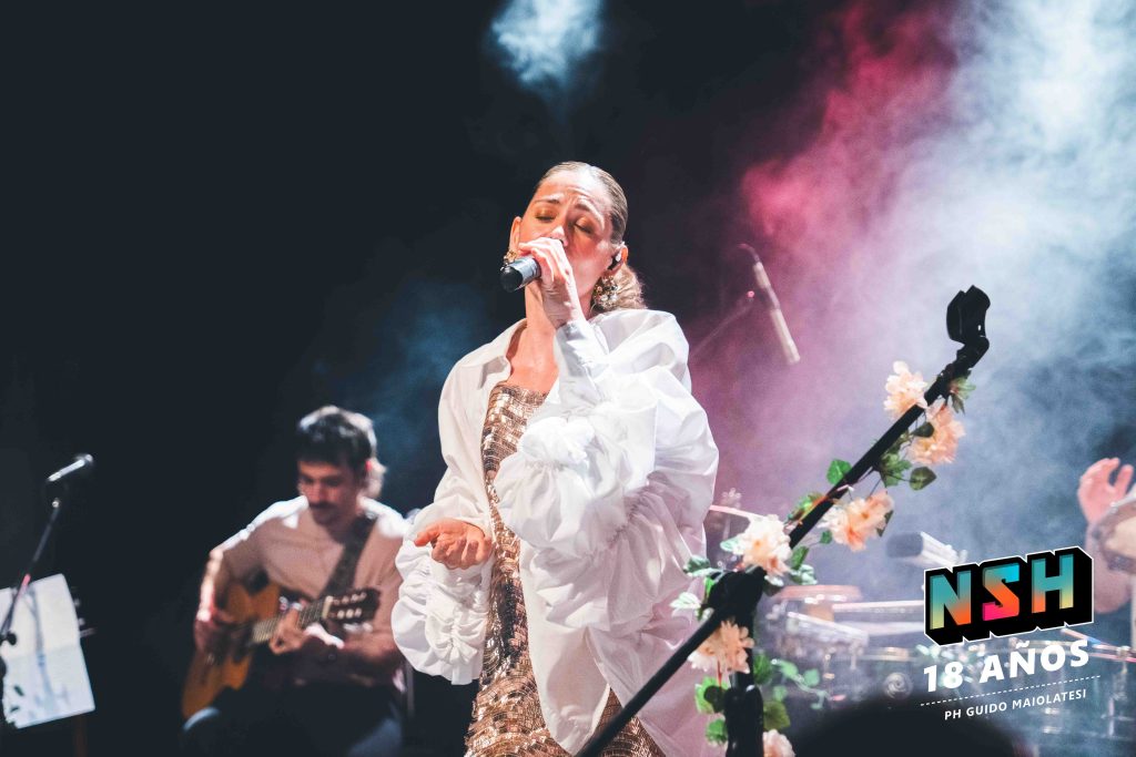 Rocío Igarzábal interpretando canciones de Volare en vivo en La Tangente
Escena del show de Rocío Igarzábal con vestuario etéreo durante Volare
El público emocionado en el recital de Rocío Igarzábal en Buenos Aires
Dueto entre Rocío Igarzábal y El Purre en La Tangente
Cambio de vestuario de Rocío Igarzábal en su presentación de Volare
Potra y Rocío Igarzábal en una interpretación íntima durante el show
Vista del escenario iluminado durante el concierto de Volare en La Tangente
Rocío Igarzábal celebrando con el público al final de su show en vivo
Momentos festivos del recital de Rocío Igarzábal con coreografía y luces
Detalle del EP Volare presentado por Rocío Igarzábal en La Tangente