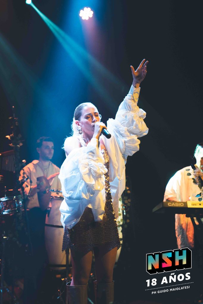 Rocío Igarzábal interpretando canciones de Volare en vivo en La Tangente
Escena del show de Rocío Igarzábal con vestuario etéreo durante Volare
El público emocionado en el recital de Rocío Igarzábal en Buenos Aires
Dueto entre Rocío Igarzábal y El Purre en La Tangente
Cambio de vestuario de Rocío Igarzábal en su presentación de Volare
Potra y Rocío Igarzábal en una interpretación íntima durante el show
Vista del escenario iluminado durante el concierto de Volare en La Tangente
Rocío Igarzábal celebrando con el público al final de su show en vivo
Momentos festivos del recital de Rocío Igarzábal con coreografía y luces
Detalle del EP Volare presentado por Rocío Igarzábal en La Tangente