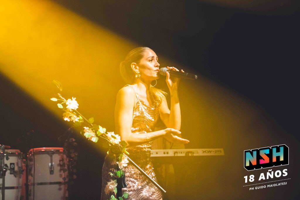 Rocío Igarzábal interpretando canciones de Volare en vivo en La Tangente
Escena del show de Rocío Igarzábal con vestuario etéreo durante Volare
El público emocionado en el recital de Rocío Igarzábal en Buenos Aires
Dueto entre Rocío Igarzábal y El Purre en La Tangente
Cambio de vestuario de Rocío Igarzábal en su presentación de Volare
Potra y Rocío Igarzábal en una interpretación íntima durante el show
Vista del escenario iluminado durante el concierto de Volare en La Tangente
Rocío Igarzábal celebrando con el público al final de su show en vivo
Momentos festivos del recital de Rocío Igarzábal con coreografía y luces
Detalle del EP Volare presentado por Rocío Igarzábal en La Tangente