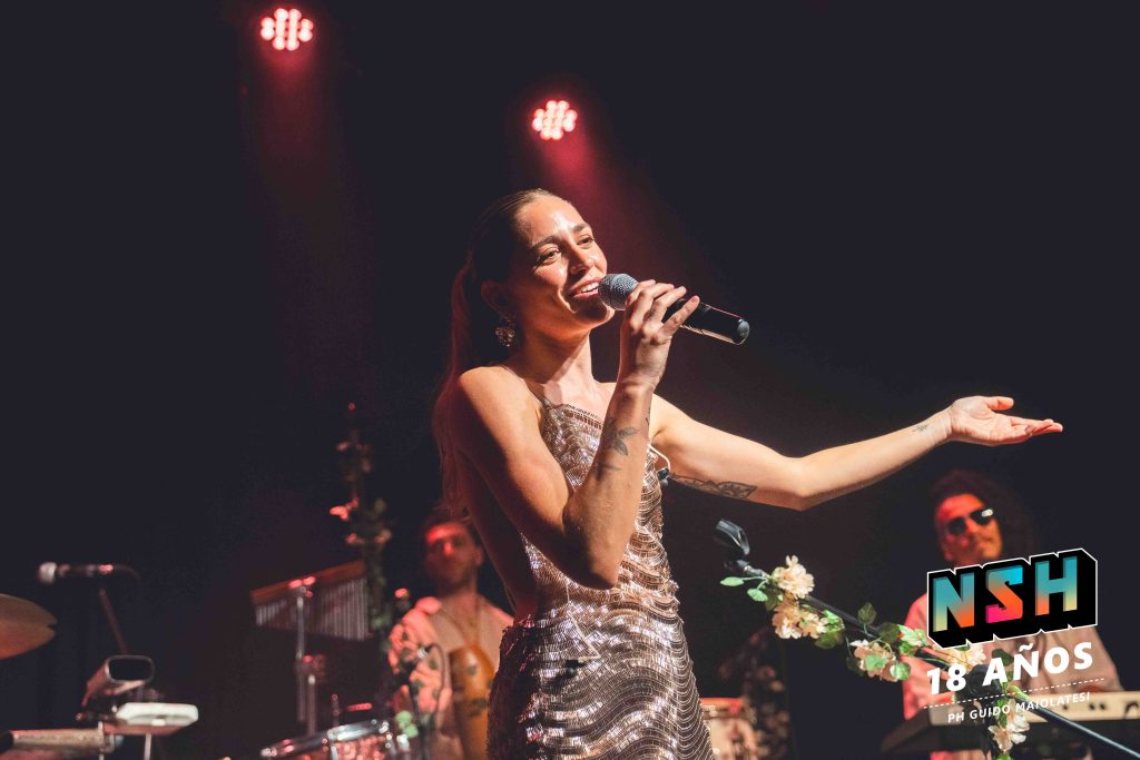 Rocío Igarzábal interpretando canciones de Volare en vivo en La Tangente
Escena del show de Rocío Igarzábal con vestuario etéreo durante Volare
El público emocionado en el recital de Rocío Igarzábal en Buenos Aires
Dueto entre Rocío Igarzábal y El Purre en La Tangente
Cambio de vestuario de Rocío Igarzábal en su presentación de Volare
Potra y Rocío Igarzábal en una interpretación íntima durante el show
Vista del escenario iluminado durante el concierto de Volare en La Tangente
Rocío Igarzábal celebrando con el público al final de su show en vivo
Momentos festivos del recital de Rocío Igarzábal con coreografía y luces
Detalle del EP Volare presentado por Rocío Igarzábal en La Tangente