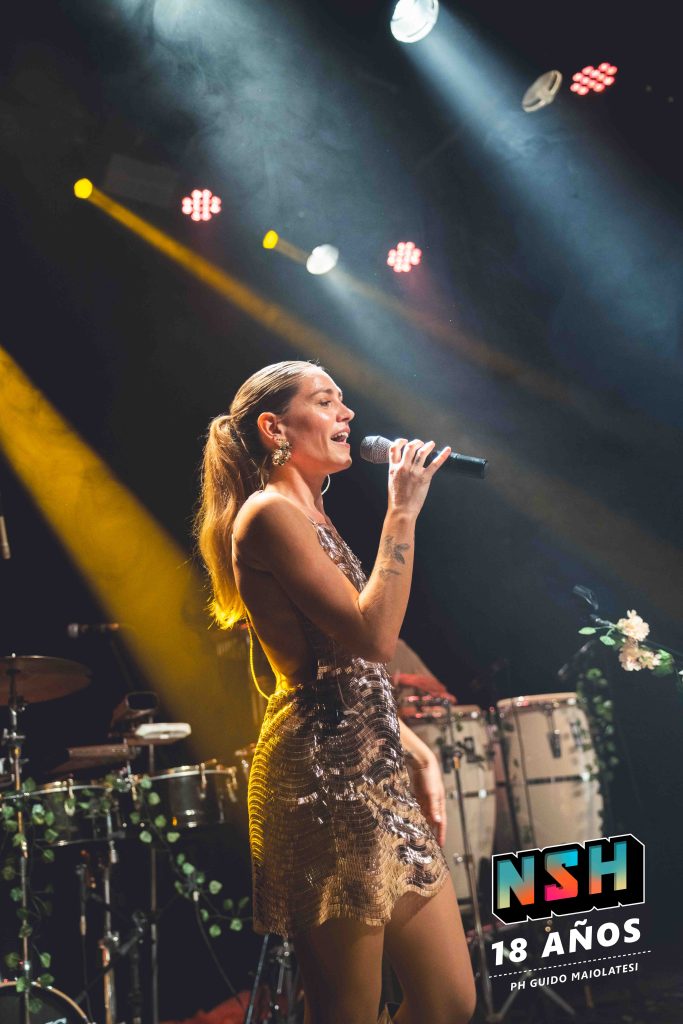 Rocío Igarzábal interpretando canciones de Volare en vivo en La Tangente
Escena del show de Rocío Igarzábal con vestuario etéreo durante Volare
El público emocionado en el recital de Rocío Igarzábal en Buenos Aires
Dueto entre Rocío Igarzábal y El Purre en La Tangente
Cambio de vestuario de Rocío Igarzábal en su presentación de Volare
Potra y Rocío Igarzábal en una interpretación íntima durante el show
Vista del escenario iluminado durante el concierto de Volare en La Tangente
Rocío Igarzábal celebrando con el público al final de su show en vivo
Momentos festivos del recital de Rocío Igarzábal con coreografía y luces
Detalle del EP Volare presentado por Rocío Igarzábal en La Tangente