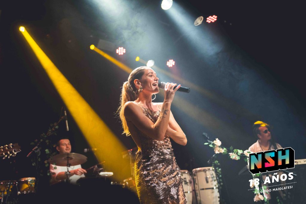 Rocío Igarzábal interpretando canciones de Volare en vivo en La Tangente
Escena del show de Rocío Igarzábal con vestuario etéreo durante Volare
El público emocionado en el recital de Rocío Igarzábal en Buenos Aires
Dueto entre Rocío Igarzábal y El Purre en La Tangente
Cambio de vestuario de Rocío Igarzábal en su presentación de Volare
Potra y Rocío Igarzábal en una interpretación íntima durante el show
Vista del escenario iluminado durante el concierto de Volare en La Tangente
Rocío Igarzábal celebrando con el público al final de su show en vivo
Momentos festivos del recital de Rocío Igarzábal con coreografía y luces
Detalle del EP Volare presentado por Rocío Igarzábal en La Tangente