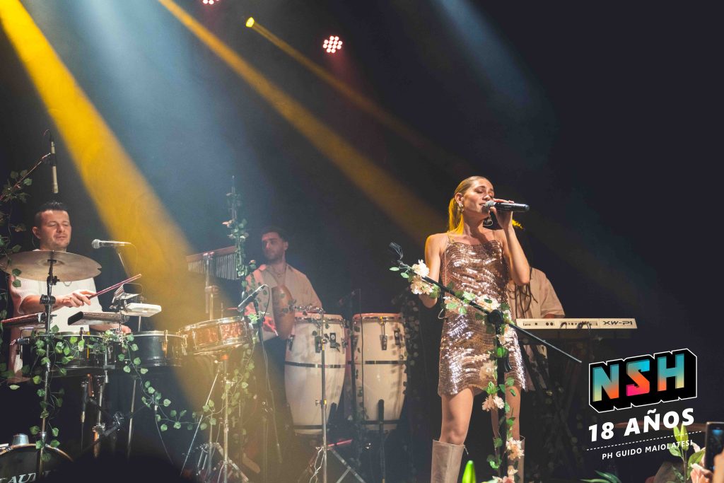 Rocío Igarzábal interpretando canciones de Volare en vivo en La Tangente
Escena del show de Rocío Igarzábal con vestuario etéreo durante Volare
El público emocionado en el recital de Rocío Igarzábal en Buenos Aires
Dueto entre Rocío Igarzábal y El Purre en La Tangente
Cambio de vestuario de Rocío Igarzábal en su presentación de Volare
Potra y Rocío Igarzábal en una interpretación íntima durante el show
Vista del escenario iluminado durante el concierto de Volare en La Tangente
Rocío Igarzábal celebrando con el público al final de su show en vivo
Momentos festivos del recital de Rocío Igarzábal con coreografía y luces
Detalle del EP Volare presentado por Rocío Igarzábal en La Tangente