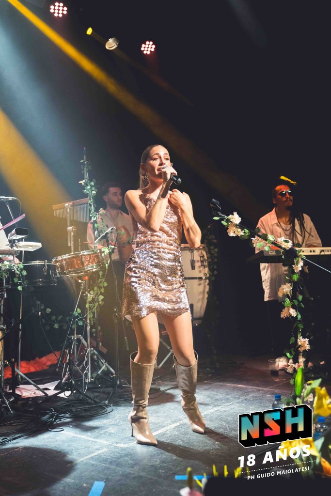 Rocío Igarzábal interpretando canciones de Volare en vivo en La Tangente
Escena del show de Rocío Igarzábal con vestuario etéreo durante Volare
El público emocionado en el recital de Rocío Igarzábal en Buenos Aires
Dueto entre Rocío Igarzábal y El Purre en La Tangente
Cambio de vestuario de Rocío Igarzábal en su presentación de Volare
Potra y Rocío Igarzábal en una interpretación íntima durante el show
Vista del escenario iluminado durante el concierto de Volare en La Tangente
Rocío Igarzábal celebrando con el público al final de su show en vivo
Momentos festivos del recital de Rocío Igarzábal con coreografía y luces
Detalle del EP Volare presentado por Rocío Igarzábal en La Tangente