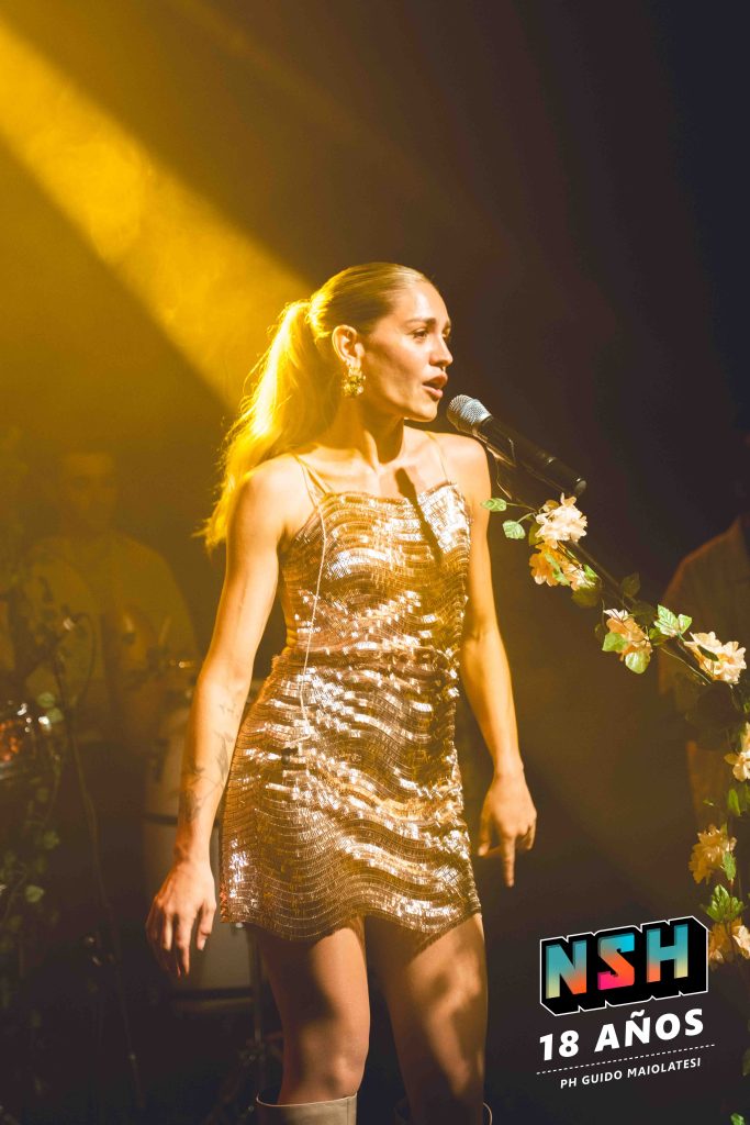 Rocío Igarzábal interpretando canciones de Volare en vivo en La Tangente
Escena del show de Rocío Igarzábal con vestuario etéreo durante Volare
El público emocionado en el recital de Rocío Igarzábal en Buenos Aires
Dueto entre Rocío Igarzábal y El Purre en La Tangente
Cambio de vestuario de Rocío Igarzábal en su presentación de Volare
Potra y Rocío Igarzábal en una interpretación íntima durante el show
Vista del escenario iluminado durante el concierto de Volare en La Tangente
Rocío Igarzábal celebrando con el público al final de su show en vivo
Momentos festivos del recital de Rocío Igarzábal con coreografía y luces
Detalle del EP Volare presentado por Rocío Igarzábal en La Tangente