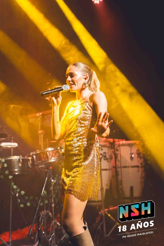 Rocío Igarzábal interpretando canciones de Volare en vivo en La Tangente
Escena del show de Rocío Igarzábal con vestuario etéreo durante Volare
El público emocionado en el recital de Rocío Igarzábal en Buenos Aires
Dueto entre Rocío Igarzábal y El Purre en La Tangente
Cambio de vestuario de Rocío Igarzábal en su presentación de Volare
Potra y Rocío Igarzábal en una interpretación íntima durante el show
Vista del escenario iluminado durante el concierto de Volare en La Tangente
Rocío Igarzábal celebrando con el público al final de su show en vivo
Momentos festivos del recital de Rocío Igarzábal con coreografía y luces
Detalle del EP Volare presentado por Rocío Igarzábal en La Tangente