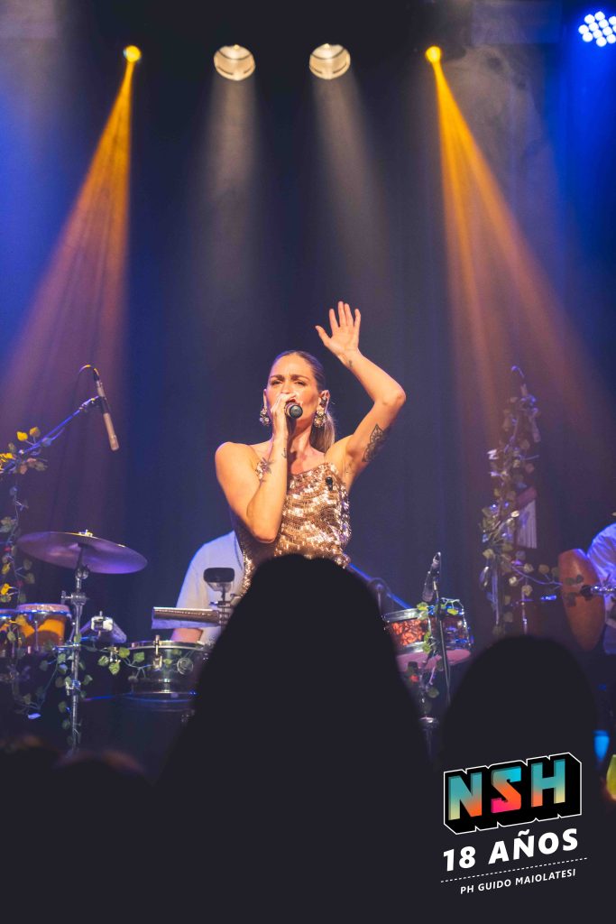 Rocío Igarzábal interpretando canciones de Volare en vivo en La Tangente
Escena del show de Rocío Igarzábal con vestuario etéreo durante Volare
El público emocionado en el recital de Rocío Igarzábal en Buenos Aires
Dueto entre Rocío Igarzábal y El Purre en La Tangente
Cambio de vestuario de Rocío Igarzábal en su presentación de Volare
Potra y Rocío Igarzábal en una interpretación íntima durante el show
Vista del escenario iluminado durante el concierto de Volare en La Tangente
Rocío Igarzábal celebrando con el público al final de su show en vivo
Momentos festivos del recital de Rocío Igarzábal con coreografía y luces
Detalle del EP Volare presentado por Rocío Igarzábal en La Tangente

- 
