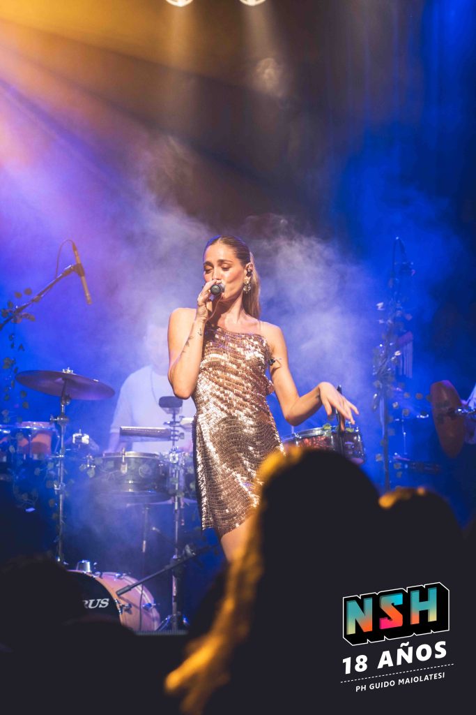 Rocío Igarzábal interpretando canciones de Volare en vivo en La Tangente
Escena del show de Rocío Igarzábal con vestuario etéreo durante Volare
El público emocionado en el recital de Rocío Igarzábal en Buenos Aires
Dueto entre Rocío Igarzábal y El Purre en La Tangente
Cambio de vestuario de Rocío Igarzábal en su presentación de Volare
Potra y Rocío Igarzábal en una interpretación íntima durante el show
Vista del escenario iluminado durante el concierto de Volare en La Tangente
Rocío Igarzábal celebrando con el público al final de su show en vivo
Momentos festivos del recital de Rocío Igarzábal con coreografía y luces
Detalle del EP Volare presentado por Rocío Igarzábal en La Tangente